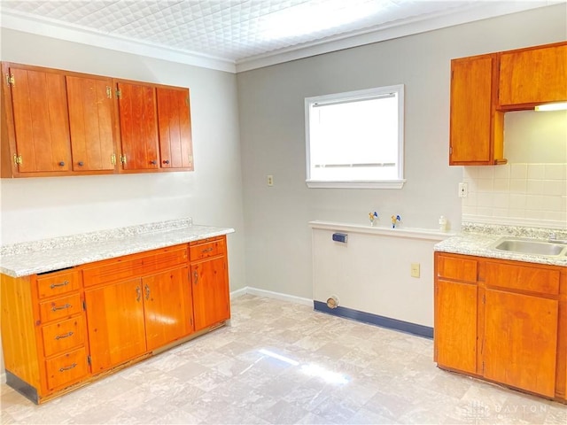 kitchen with light countertops, light floors, backsplash, and a sink