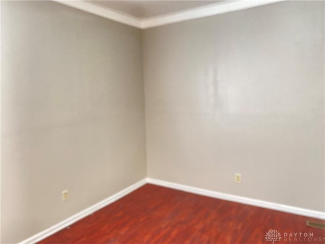 spare room featuring dark wood finished floors and baseboards