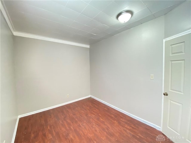 empty room with dark wood-style floors and baseboards