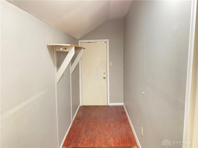 doorway featuring baseboards, wood finished floors, and vaulted ceiling