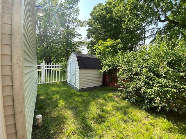 view of yard featuring fence, an outdoor structure, and a shed