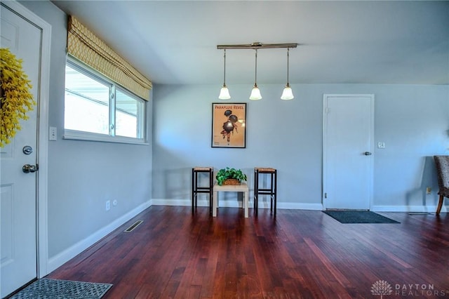 interior space with visible vents, baseboards, and wood finished floors