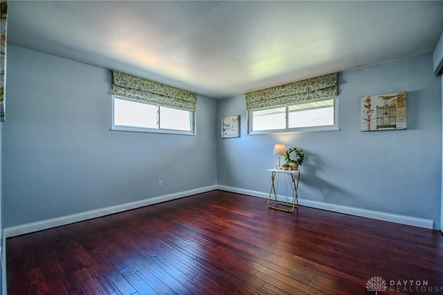 empty room featuring hardwood / wood-style floors, plenty of natural light, and baseboards