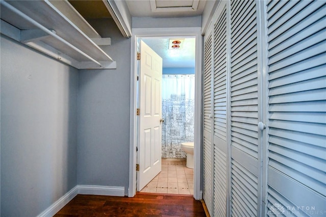 corridor featuring wood finished floors and baseboards