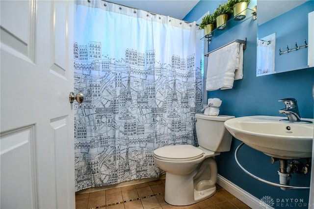 full bathroom with tile patterned flooring, a shower with shower curtain, toilet, and a sink