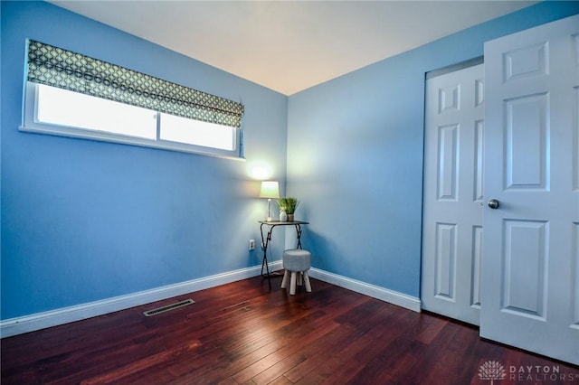 unfurnished room featuring wood finished floors, baseboards, and visible vents