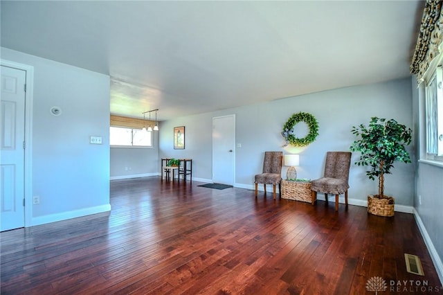 living area featuring hardwood / wood-style floors, baseboards, and visible vents