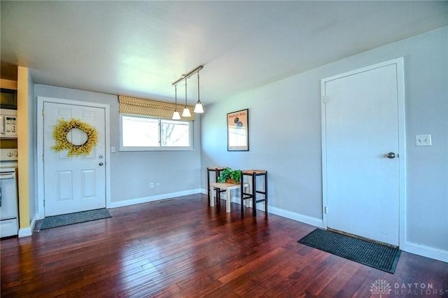 entrance foyer with rail lighting, baseboards, and hardwood / wood-style floors