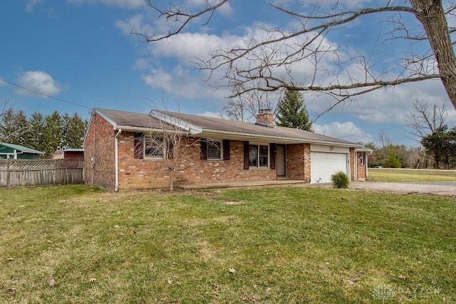 view of front facade featuring brick siding, driveway, a front yard, and fence