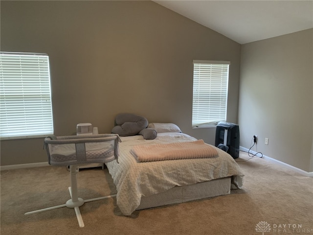 carpeted bedroom with lofted ceiling and baseboards