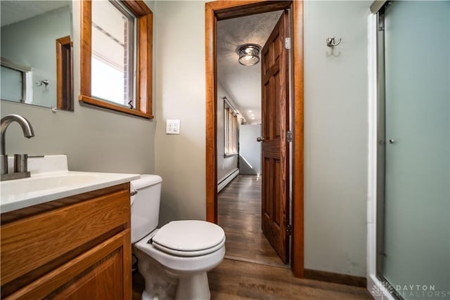 bathroom with a baseboard radiator, toilet, wood finished floors, and vanity