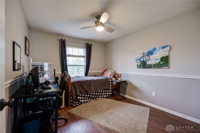 bedroom featuring dark wood finished floors, a textured ceiling, baseboards, and ceiling fan