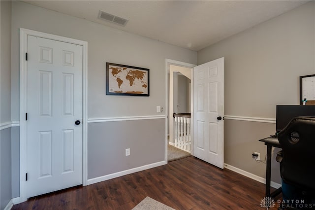 home office featuring wood finished floors, visible vents, and baseboards