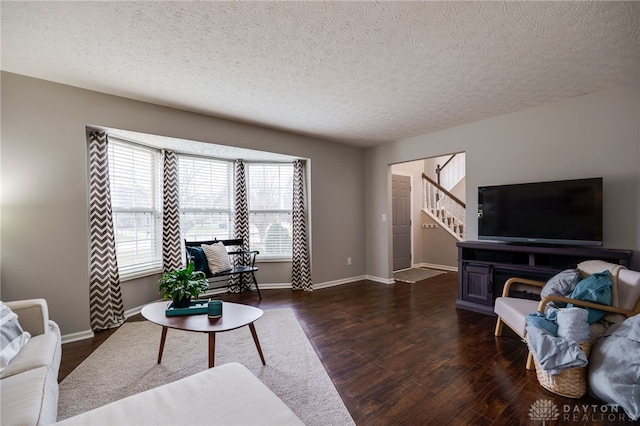 living room with stairway, baseboards, a textured ceiling, and dark wood-style floors