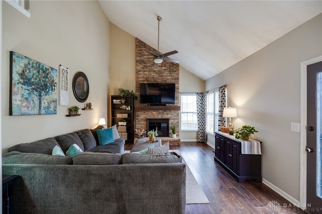 living room with a ceiling fan, baseboards, high vaulted ceiling, dark wood-type flooring, and a brick fireplace