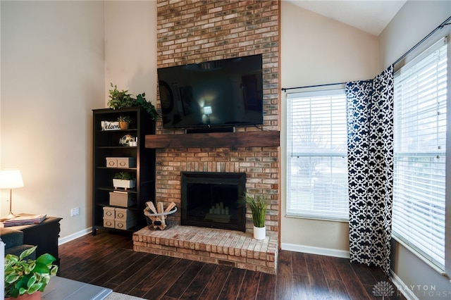 living area featuring plenty of natural light, hardwood / wood-style floors, and vaulted ceiling