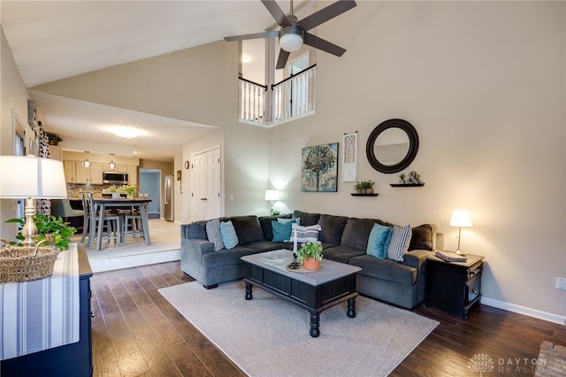 living area featuring high vaulted ceiling, dark wood-style floors, baseboards, and ceiling fan