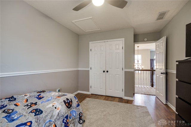 unfurnished bedroom with a closet, visible vents, baseboards, and wood finished floors