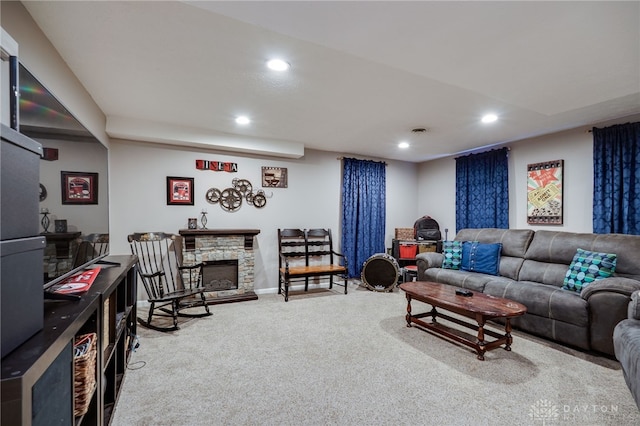 carpeted living room with recessed lighting, baseboards, and a stone fireplace