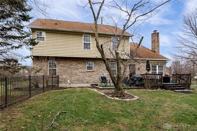 back of house featuring a wooden deck, a yard, a fenced backyard, a chimney, and brick siding