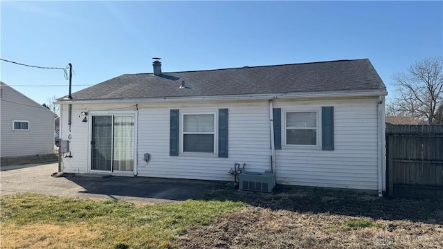 rear view of property featuring a patio, fence, and roof with shingles