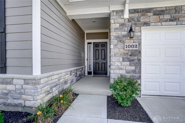 1002 Belfast Dr, Sugarcreek Township, OH 45440 - property entrance featuring a garage and stone siding