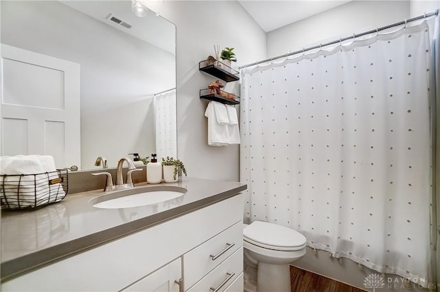 1002 Belfast Dr, Sugarcreek Township, OH 45440 - full bathroom with vanity, toilet, wood finished floors, and visible vents