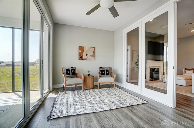 1002 Belfast Dr, Sugarcreek Township, OH 45440 - sitting room featuring a glass covered fireplace, baseboards, wood finished floors, and a ceiling fan