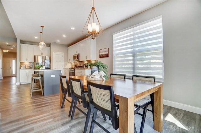 1002 Belfast Dr, Sugarcreek Township, OH 45440 - dining area with recessed lighting, baseboards, an inviting chandelier, and light wood finished floors