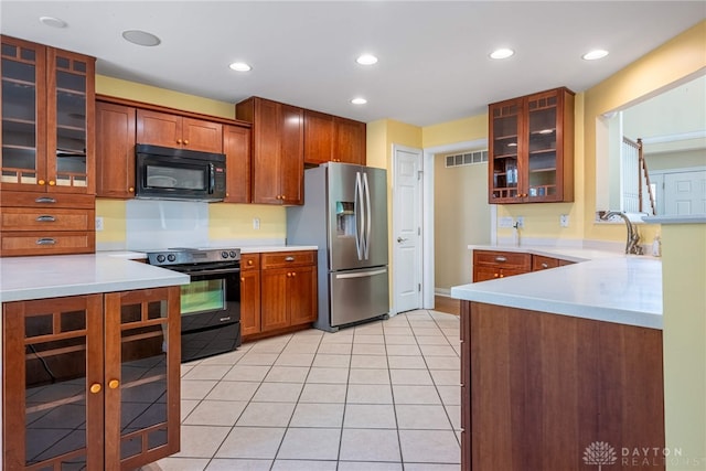 kitchen featuring visible vents, black appliances, a sink, light countertops, and light tile patterned floors