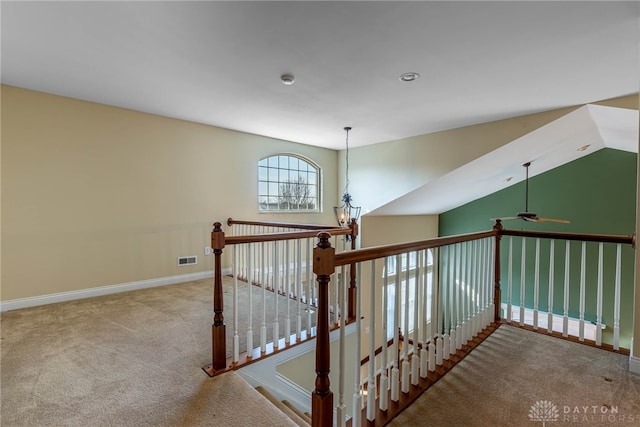 stairway with visible vents, a ceiling fan, baseboards, carpet floors, and lofted ceiling