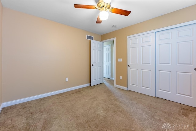 unfurnished bedroom featuring a ceiling fan, carpet, visible vents, baseboards, and a closet