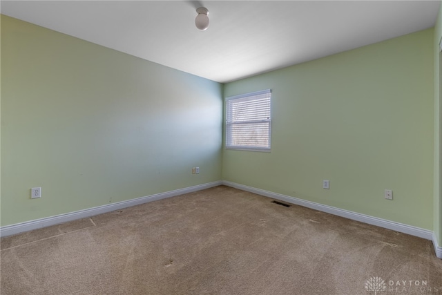 carpeted empty room with visible vents and baseboards