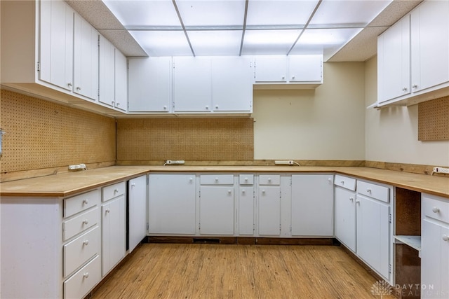 kitchen with white cabinetry, light countertops, tasteful backsplash, and light wood-type flooring