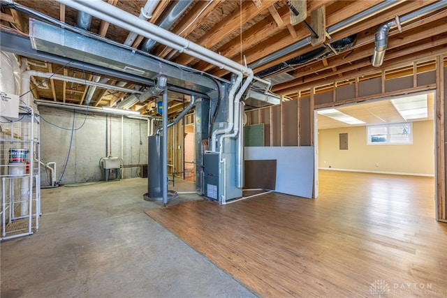 below grade area with heating unit, gas water heater, and electric panel