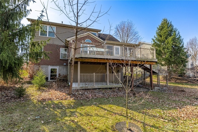 rear view of property featuring a wooden deck, brick siding, and stairs