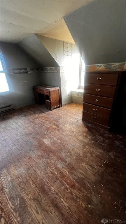 bonus room with vaulted ceiling, a baseboard heating unit, and hardwood / wood-style floors