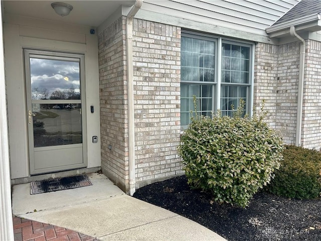 view of exterior entry featuring brick siding