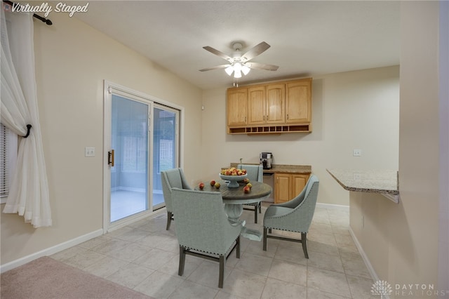 dining area with light tile patterned floors, baseboards, and ceiling fan