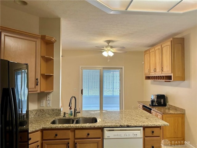 kitchen with open shelves, a peninsula, freestanding refrigerator, white dishwasher, and a sink