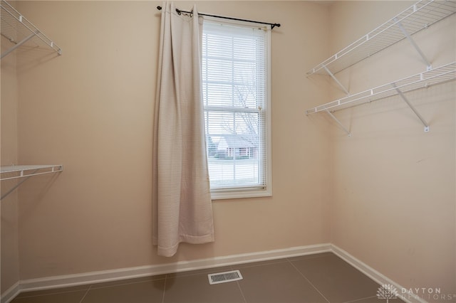 walk in closet with dark tile patterned floors and visible vents