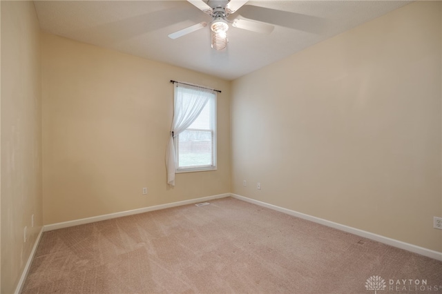 unfurnished room with light colored carpet, baseboards, and ceiling fan