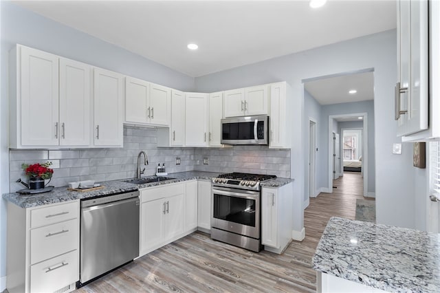 331 Morton Ave, Dayton, OH 45410 - kitchen featuring light wood finished floors, a sink, light stone countertops, and stainless steel appliances