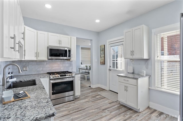 331 Morton Ave, Dayton, OH 45410 - kitchen with light stone countertops, a sink, white cabinets, and stainless steel appliances