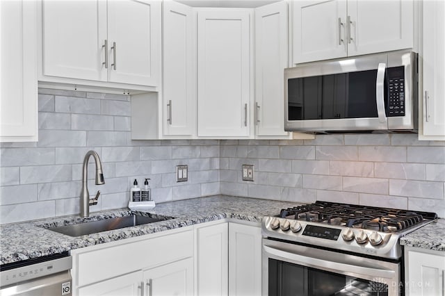 331 Morton Ave, Dayton, OH 45410 - kitchen featuring appliances with stainless steel finishes, decorative backsplash, a sink, and white cabinetry