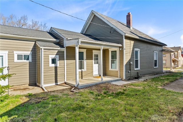 331 Morton Ave, Dayton, OH 45410 - rear view of property with a porch, a chimney, and a lawn