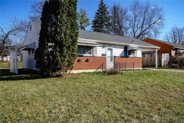 5027 Hackett Dr, Dayton, OH 45417 - view of side of home with brick siding, an attached carport, concrete driveway, and a shingled roof