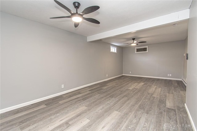 spare room featuring wood finished floors, baseboards, baseboard heating, and ceiling fan