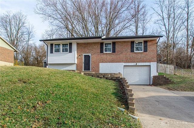raised ranch featuring brick siding, driveway, a front yard, and a garage