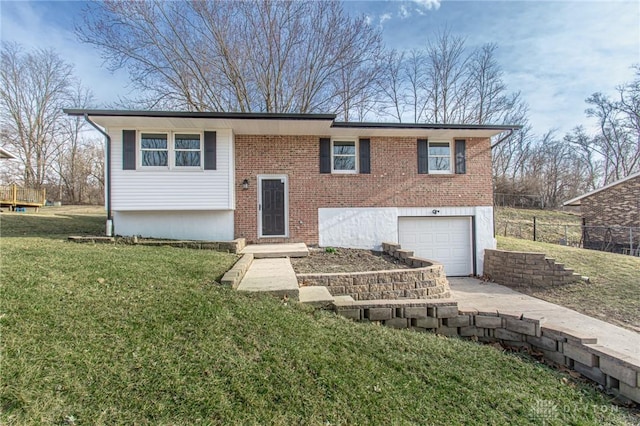 bi-level home with a garage, brick siding, concrete driveway, and a front yard